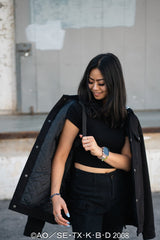 Model wearing the jacket over shoulders, highlighting the shoulder straps and sleeve art.