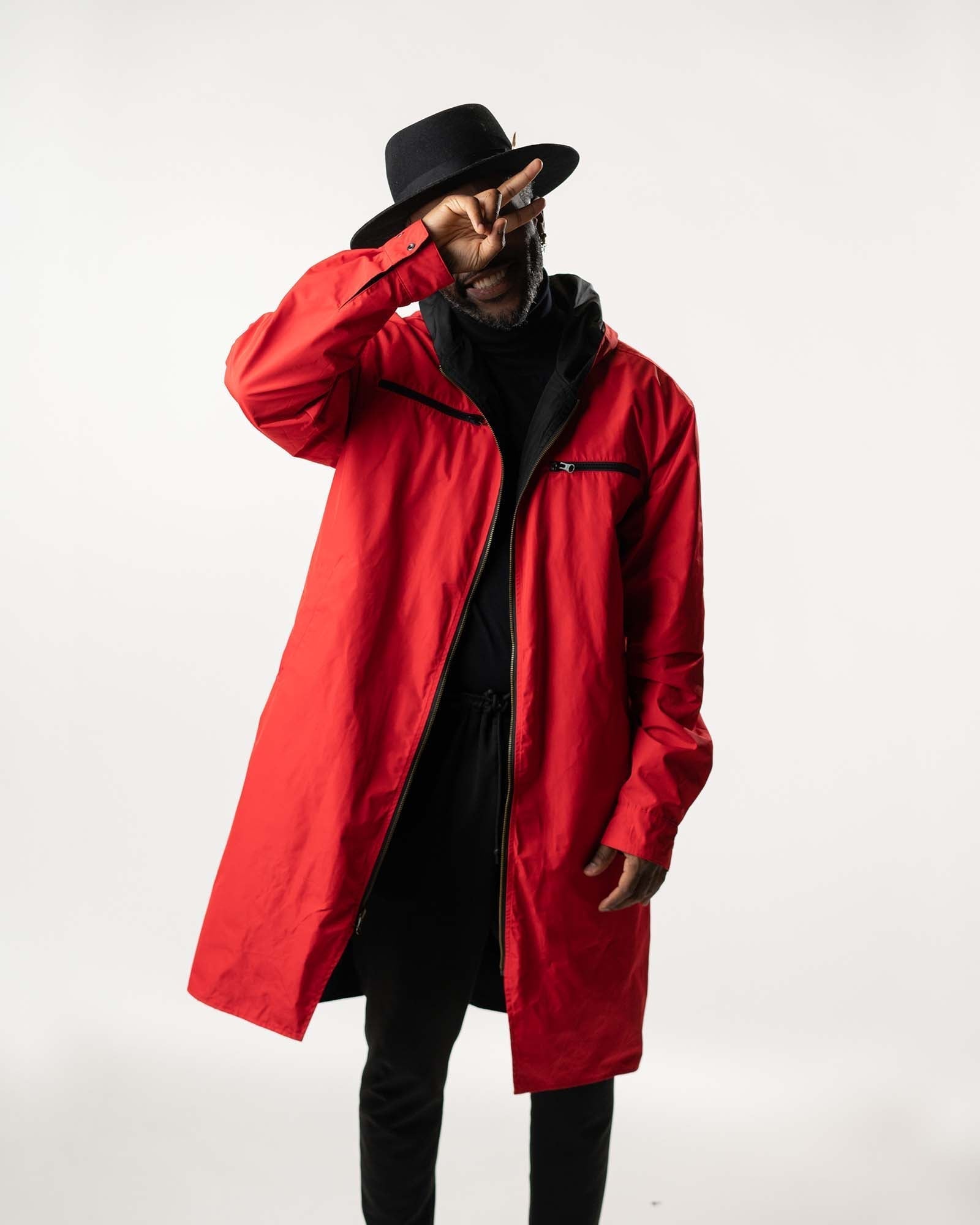 Model wearing the red side of the reversible coat, showcasing the oversized hood and fit.