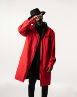 Model wearing the red side of the reversible coat, showcasing the oversized hood and fit.