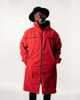 Front view of the red side of the long-line windbreaker featuring chest zipper details.