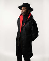 Full-length lifestyle shot of the black reversible coat with a high-fashion streetwear look.