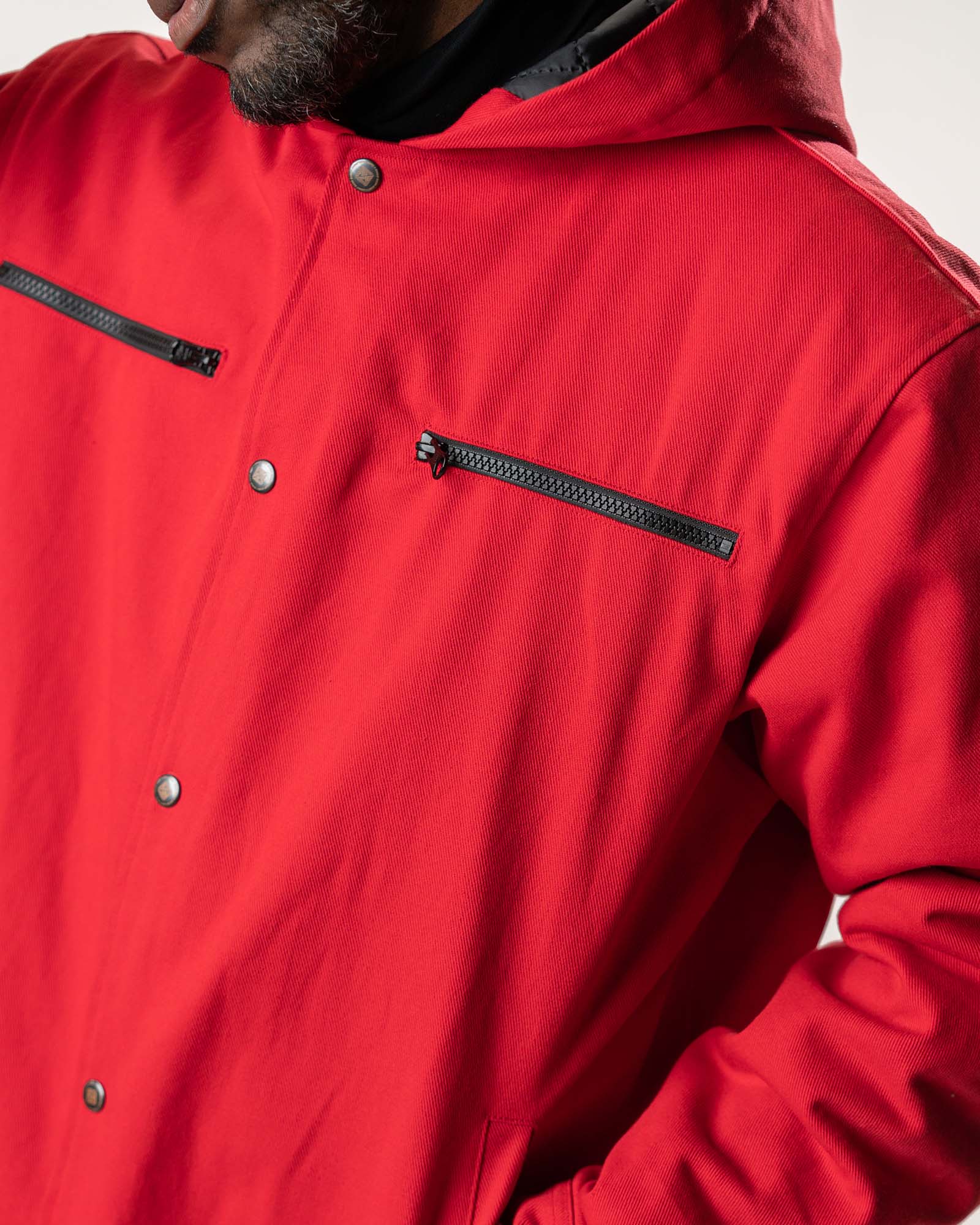 Detail shot of the black functional chest zippers and snap button hardware.