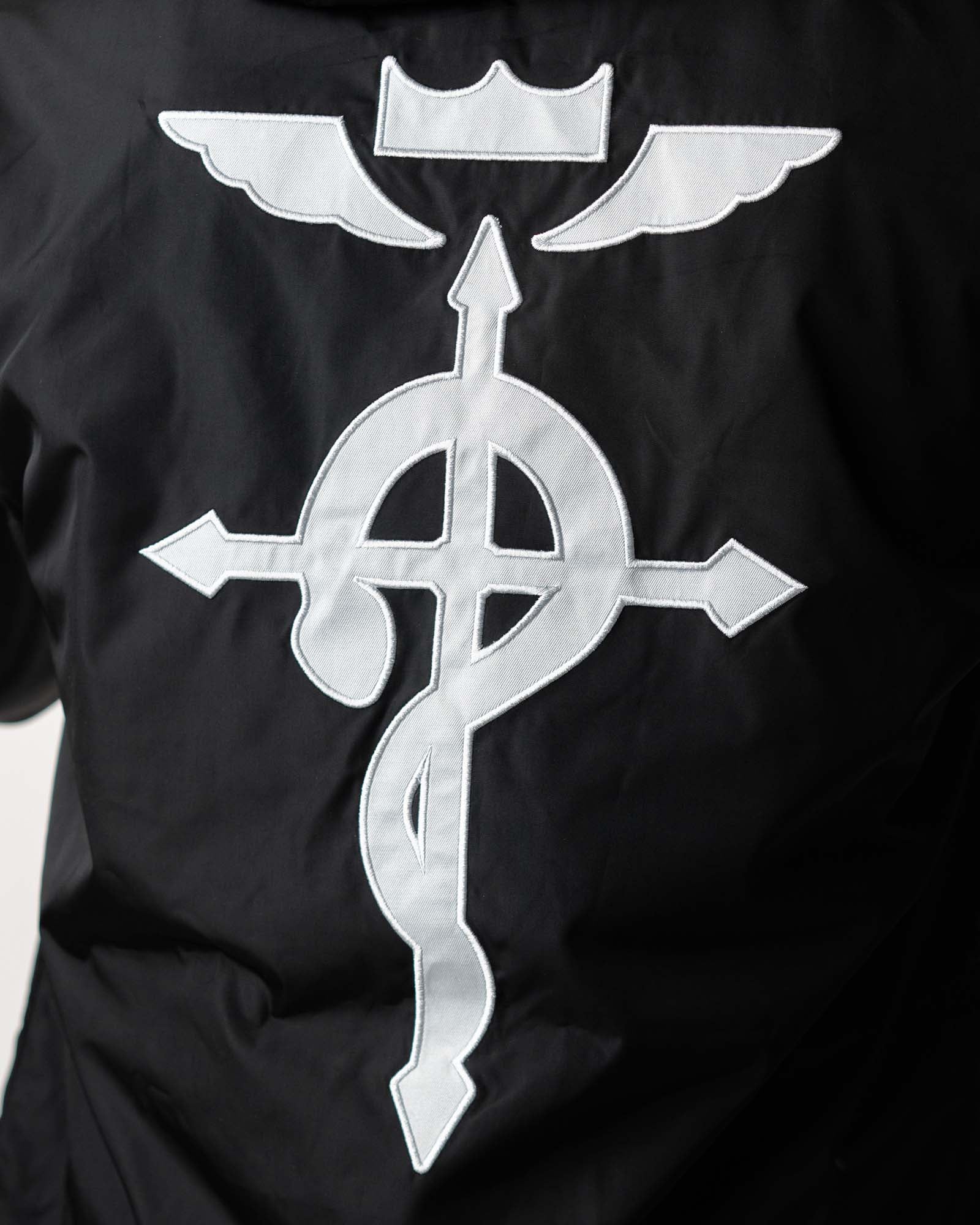 Close-up of the high-contrast Flamel symbol printed on the black water-resistant fabric.