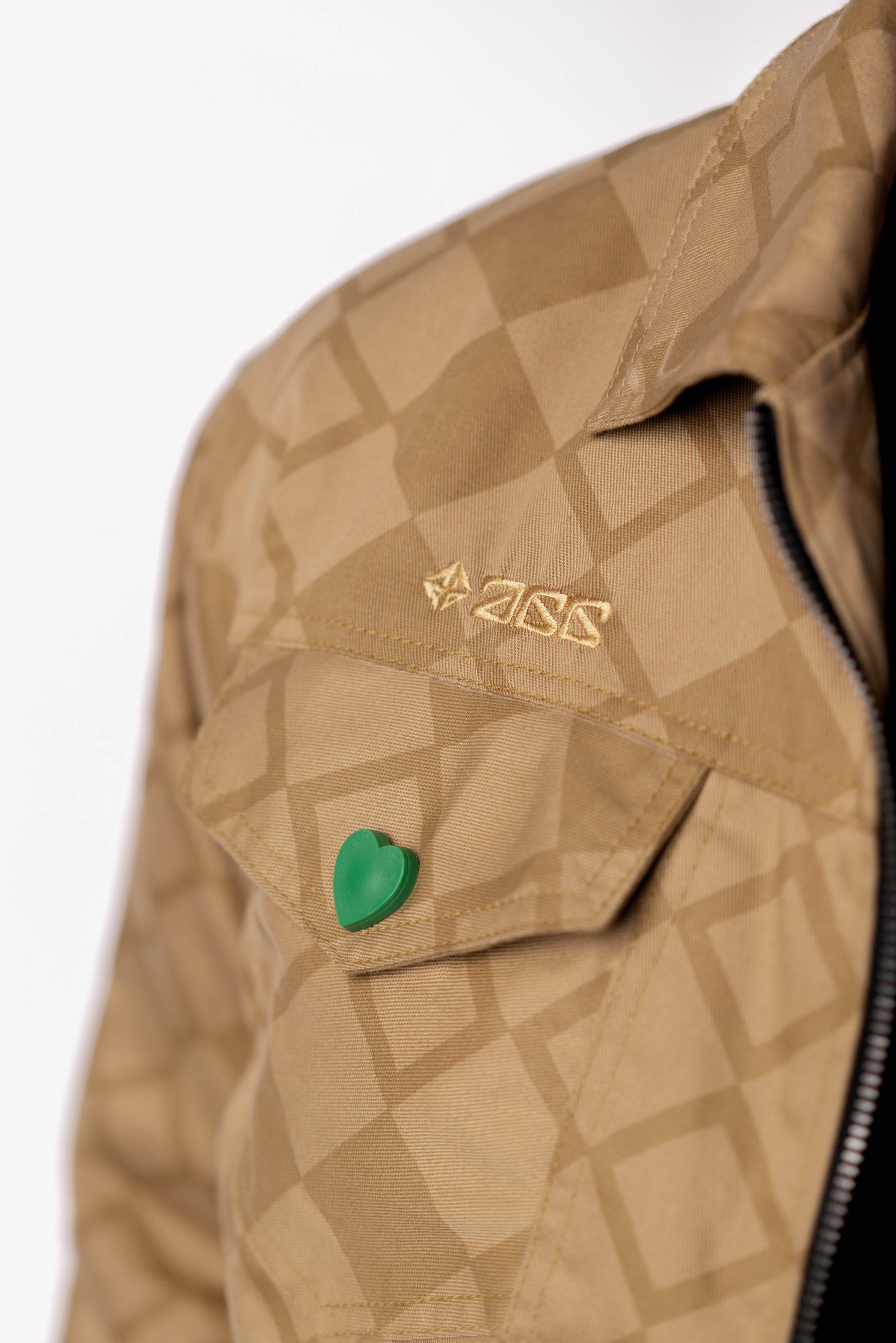 Close-up of the green heart-shaped button and gold embroidery.