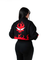 Back view of female model in cropped black Gurren Lagann jacket with red flaming skull logo.