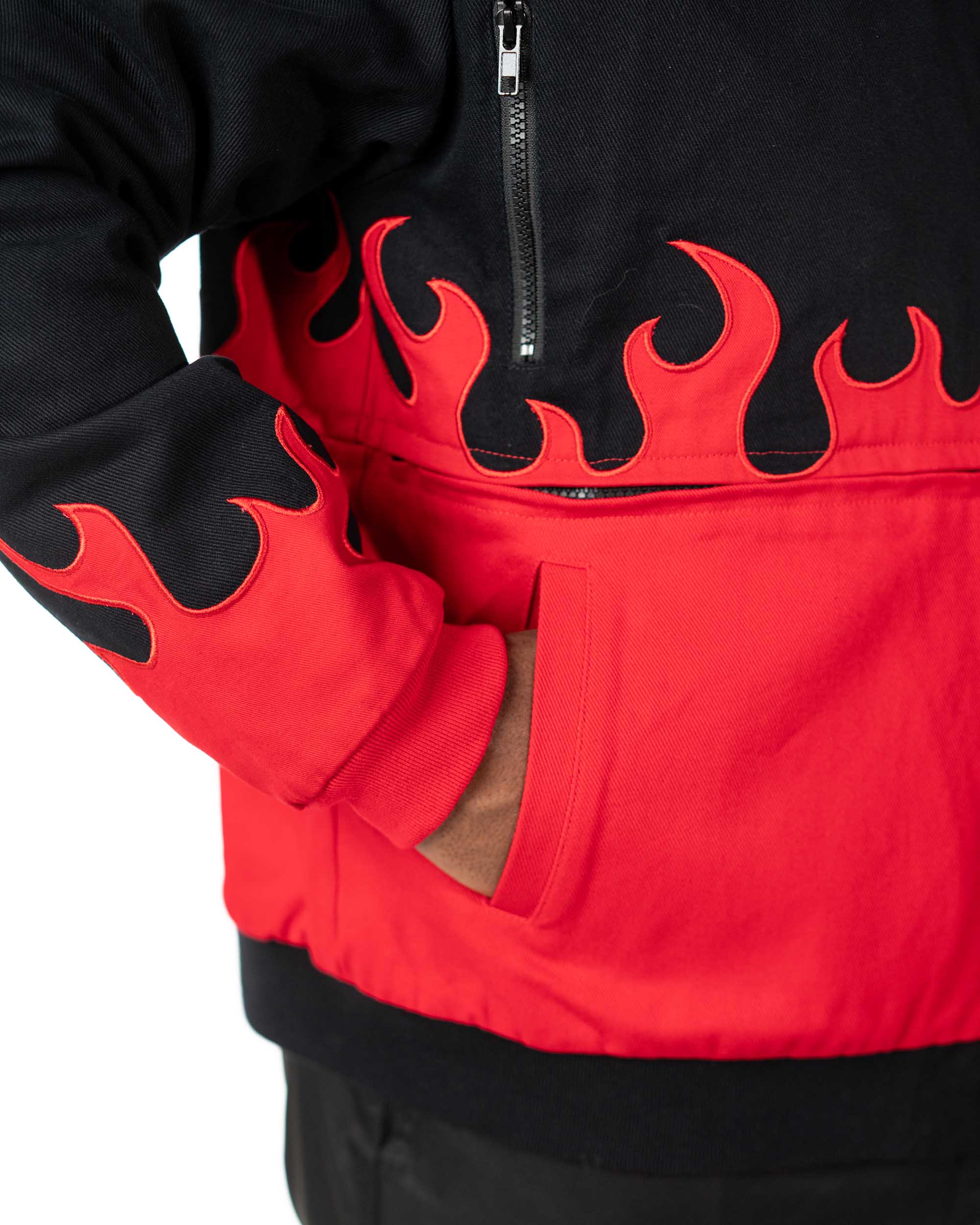 Close-up of the side pocket on the cropped black Gurren Lagann jacket, featuring a small flaming skull emblem and red flames.