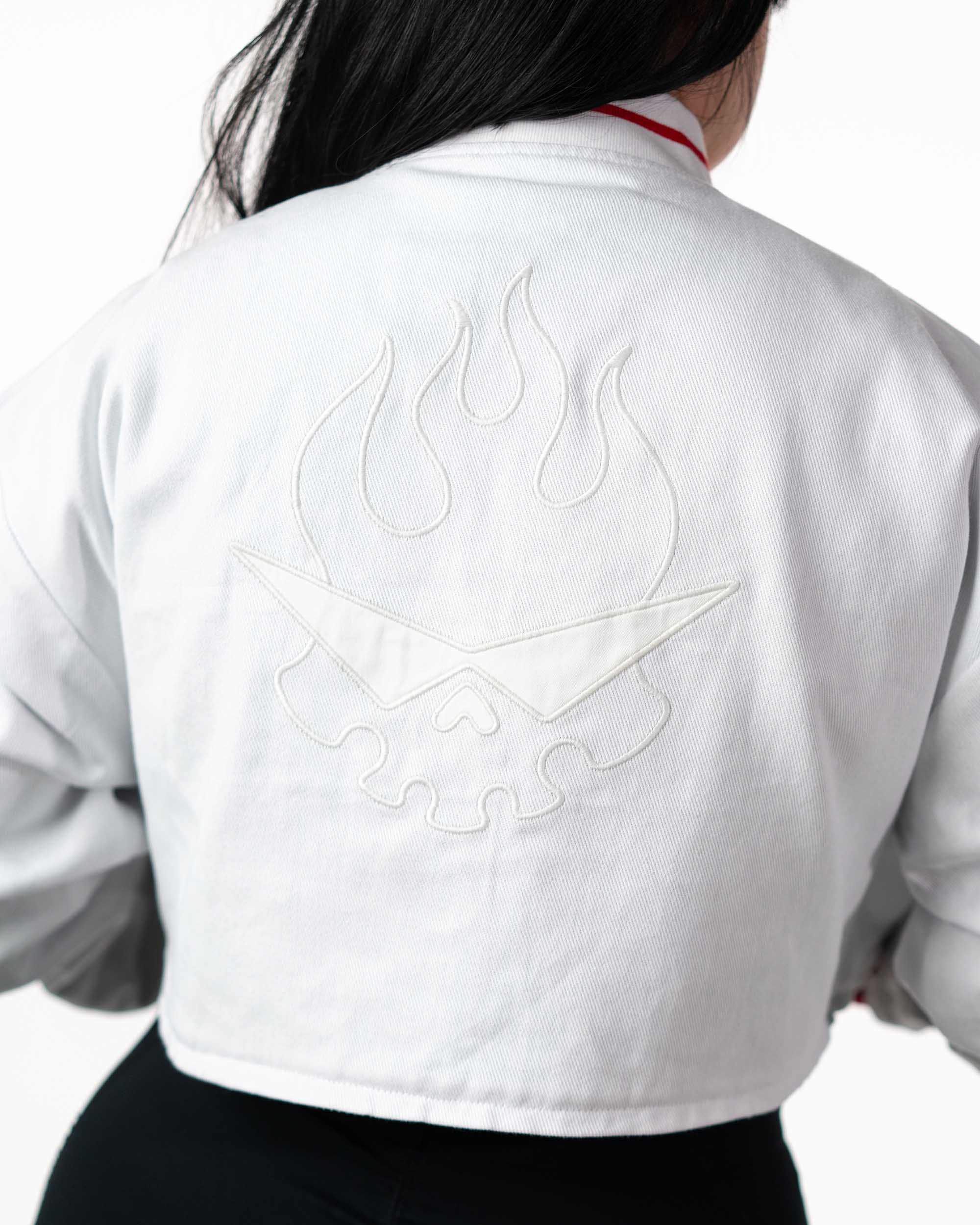 Back view of cropped white Yoko Gurren Lagann jacket on a model, showing subtle white-on-white embroidery pattern.
