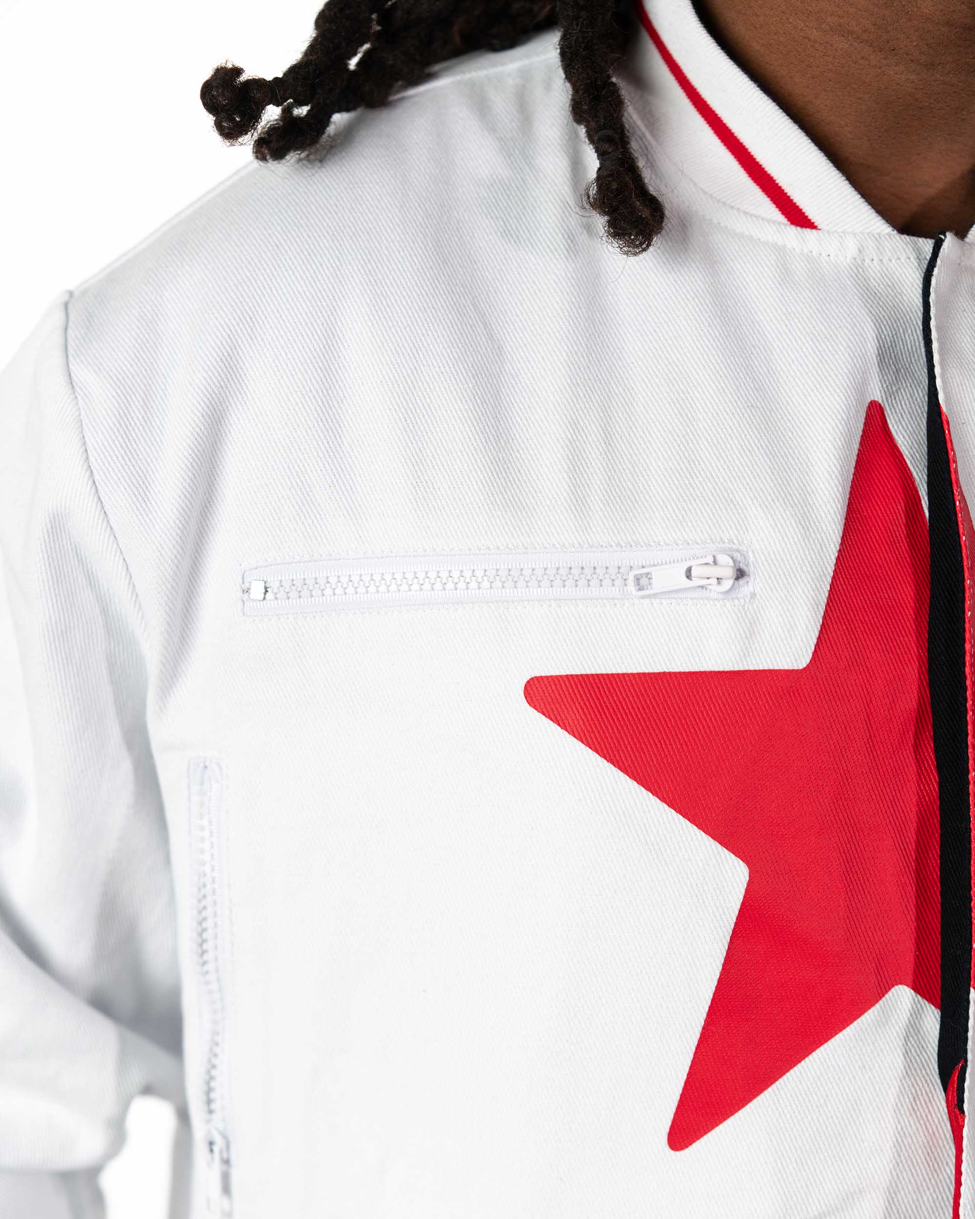 Close-up of the left sleeve of the cropped white Gurren Lagann jacket on a male model, showing a red star and red stripes.