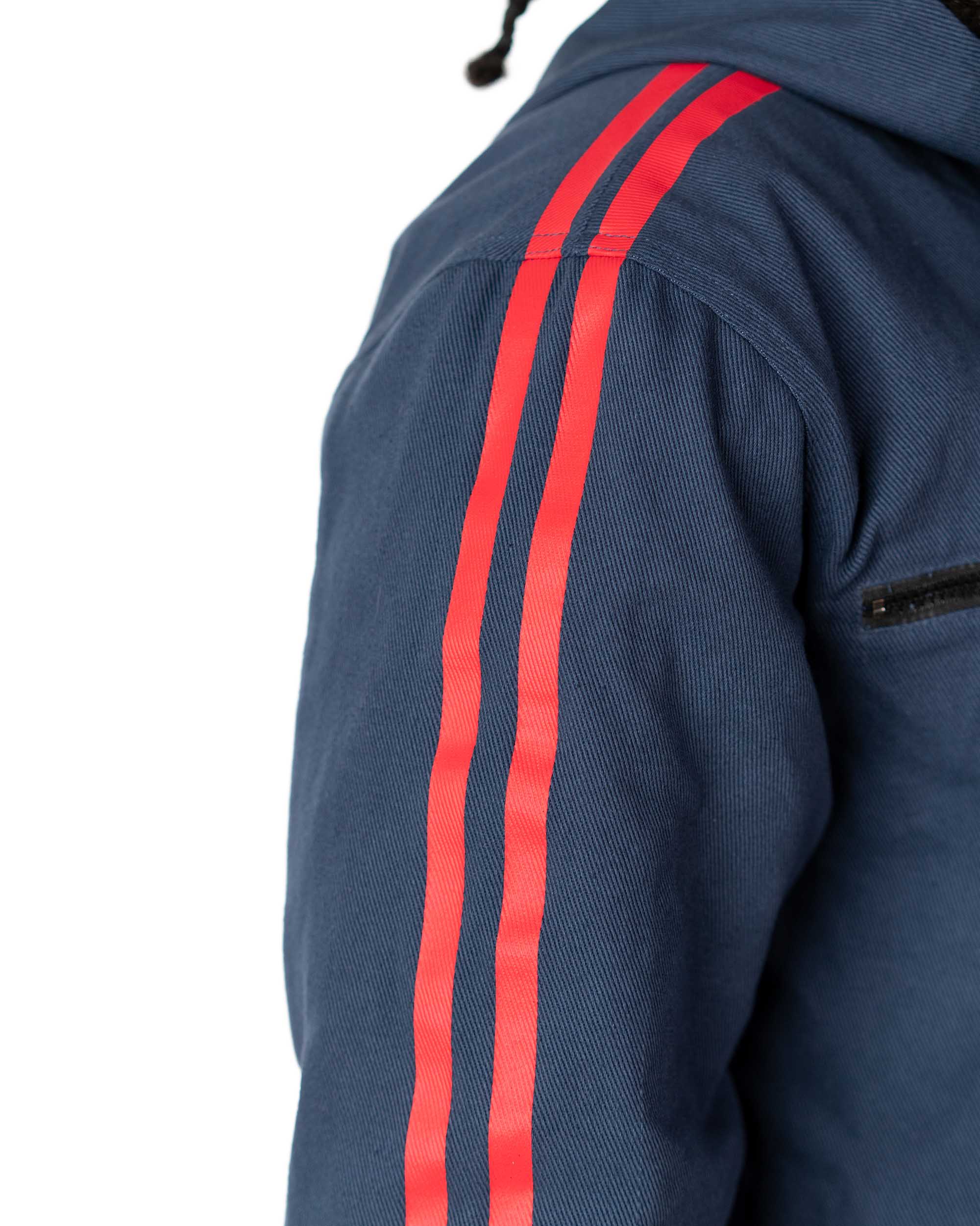 Detailed view of the red stripes printed down the sleeve of the blue denim side of the coat