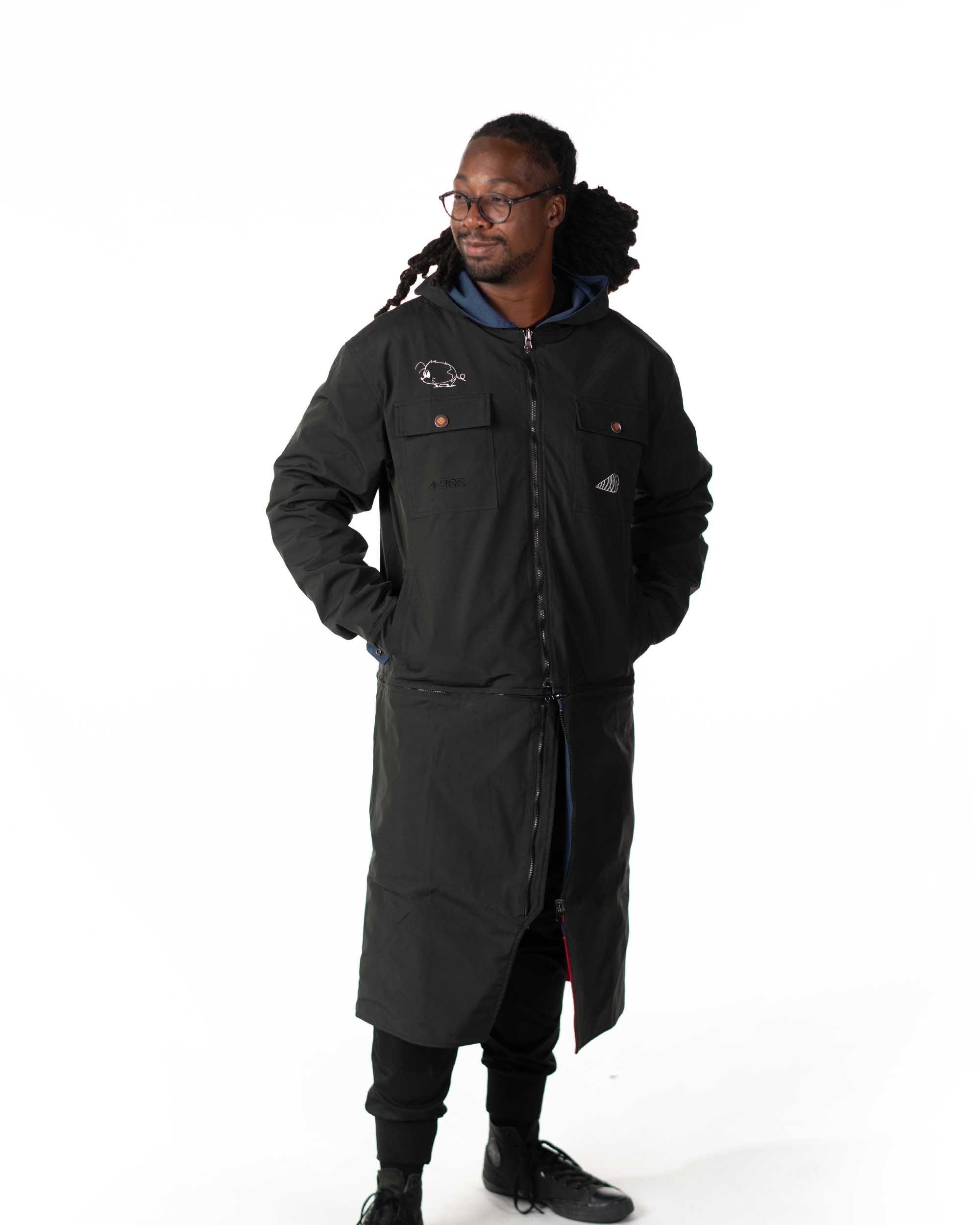 Full length front profile view of the model wearing the black polyester windbreaker side of the coat