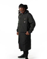 Side profile view of the Simon long coat worn on the black polyester windbreaker side with the hood up