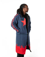 Front profile of the model wearing the full length blue denim coat showing the red star and flame hem