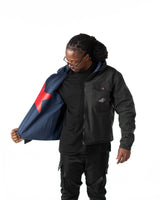 Model wearing the black short coat open to reveal the blue denim lining and reversible construction