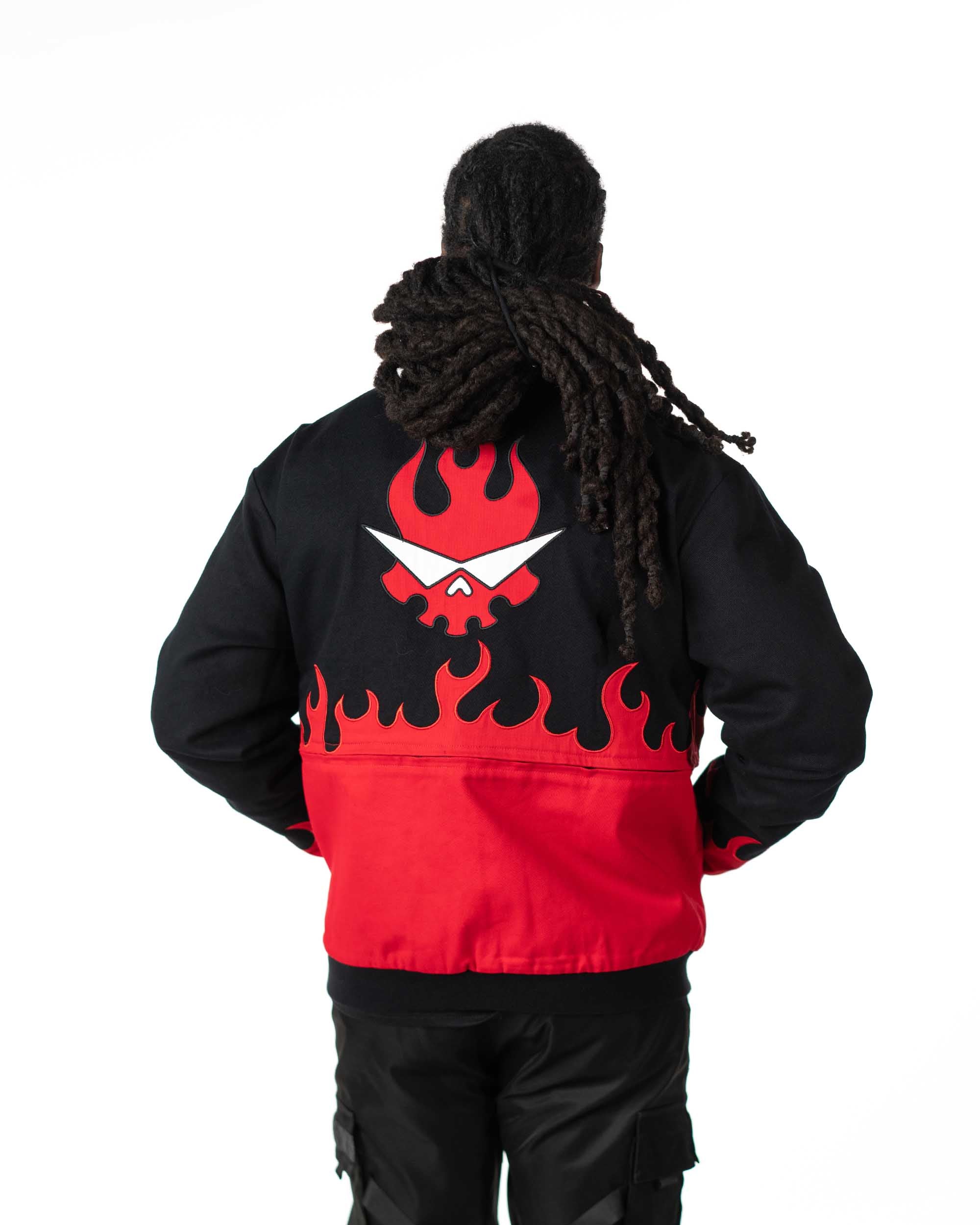 Back view of male model wearing full-length black Gurren Lagann Yoko jacket with red flaming skull logo.