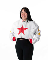 Female model in cropped white Gurren Lagann jacket with red star, full front view, smiling.