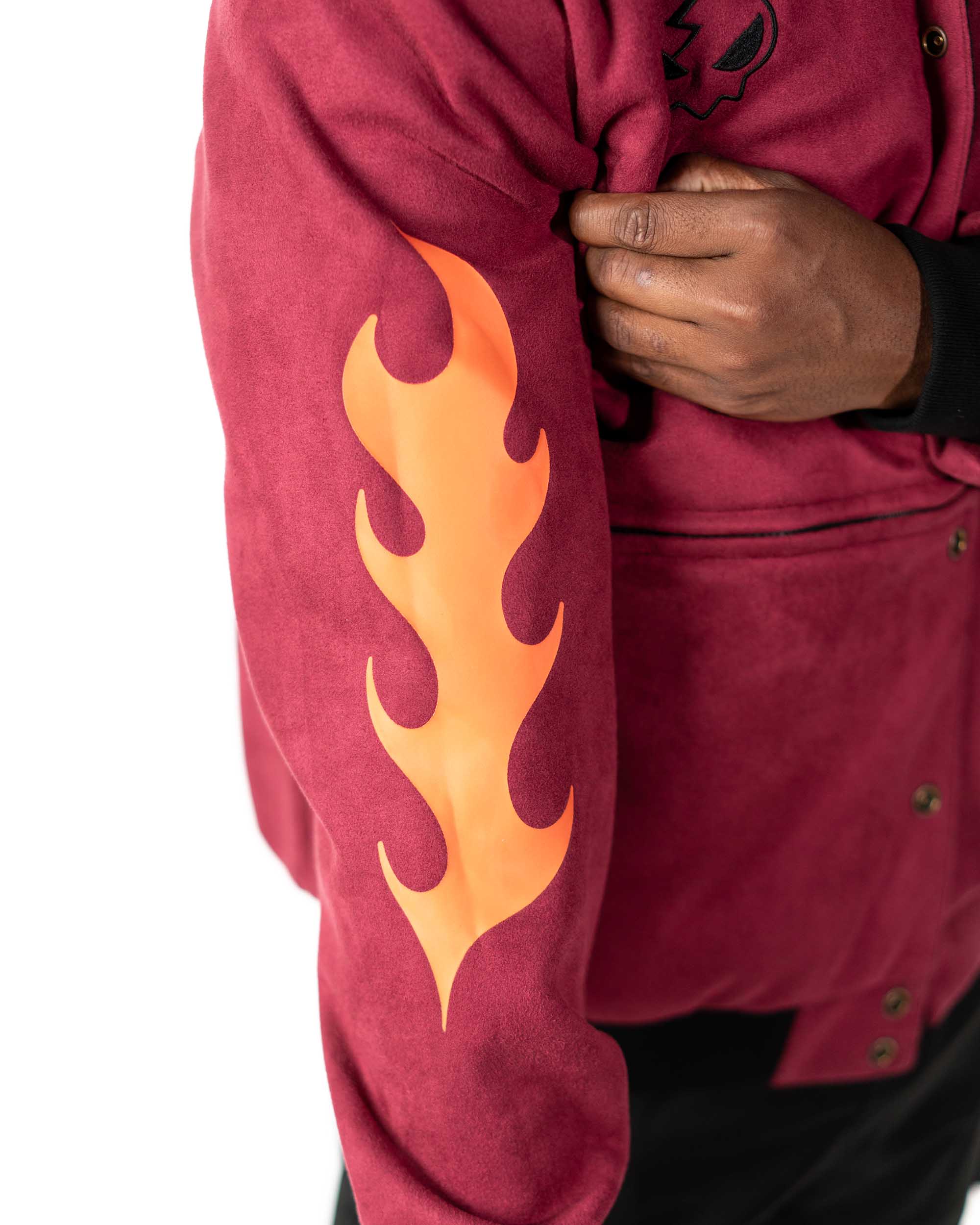 Close-up of the maroon jacket's front chest pocket featuring the solid yellow and black accent stripes