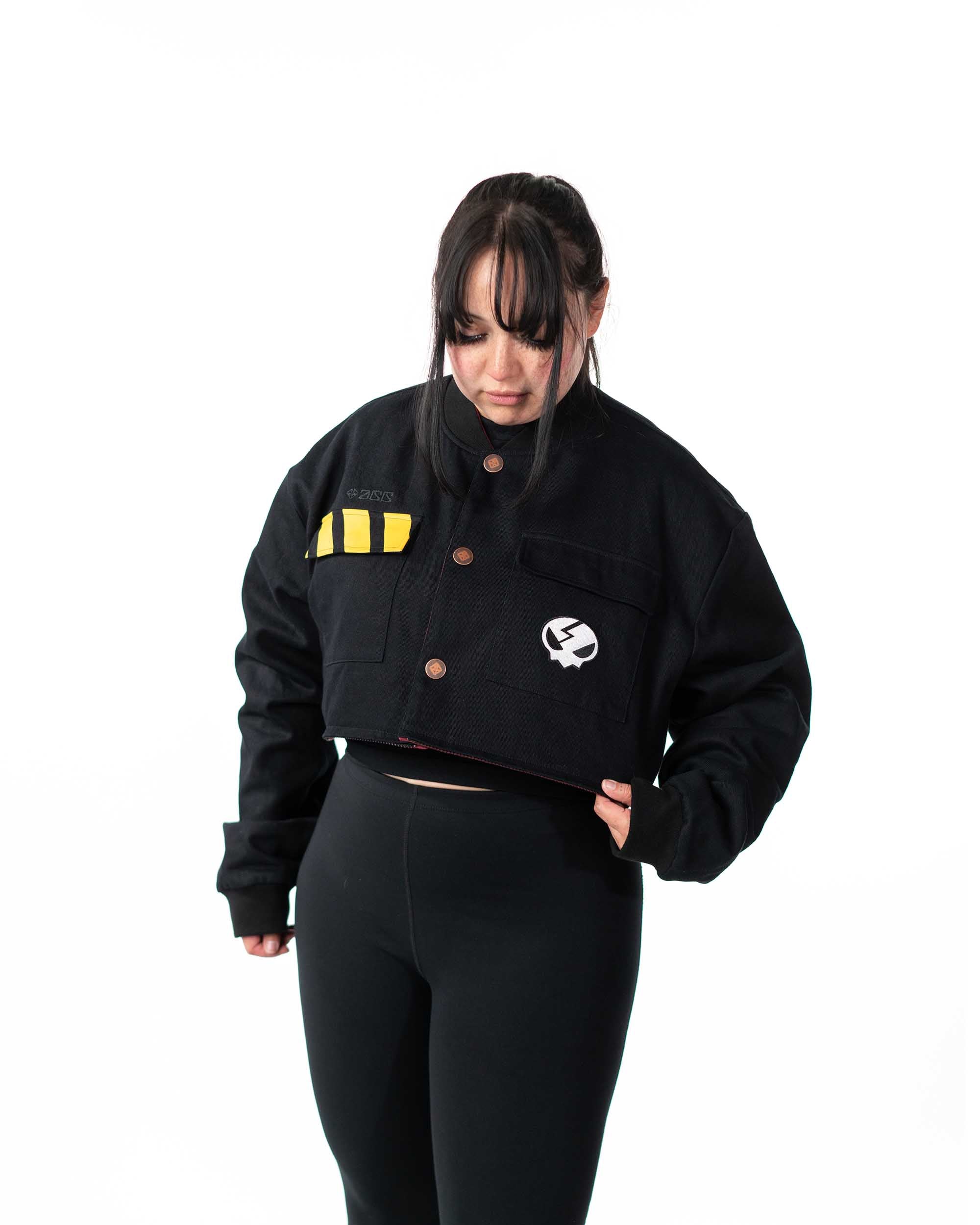 Front view of female model wearing the cropped black side of the reversible jacket with hands together