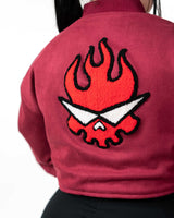 Back view close-up of female model in the cropped maroon jacket featuring the red flaming skull embroidery