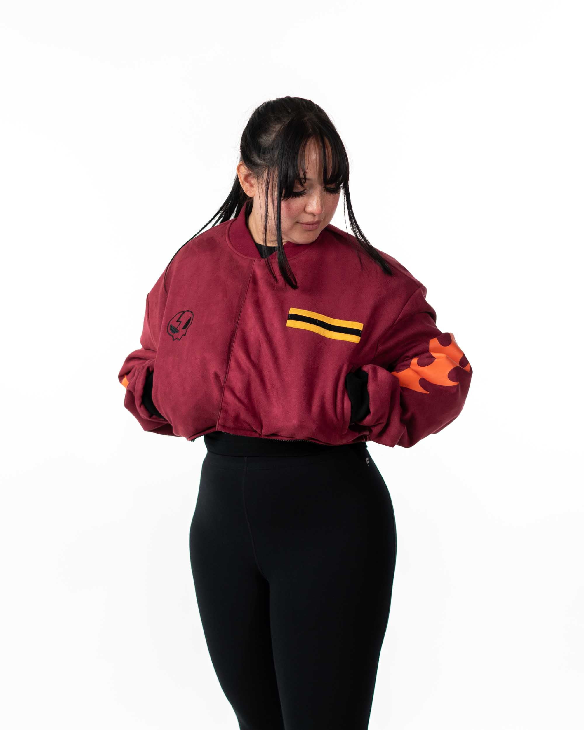 Angled front view of female model wearing the cropped maroon side of the reversible jacket