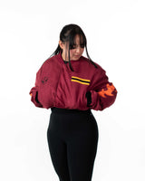 Angled front view of female model wearing the cropped maroon side of the reversible jacket
