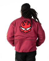 Front view of male model smiling in the black side of the full length reversible jacket with hands in pockets