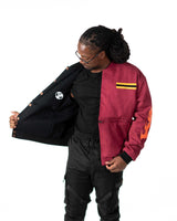 Male model pulling open the black jacket to reveal the reversible maroon side lining