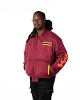 Front view of male model in the zipped maroon side of the reversible jacket with orange flame sleeve accents