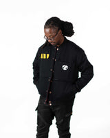 Front view of male model wearing the black side of the Gurren Lagann Yoko reversible jacket with hands in pockets