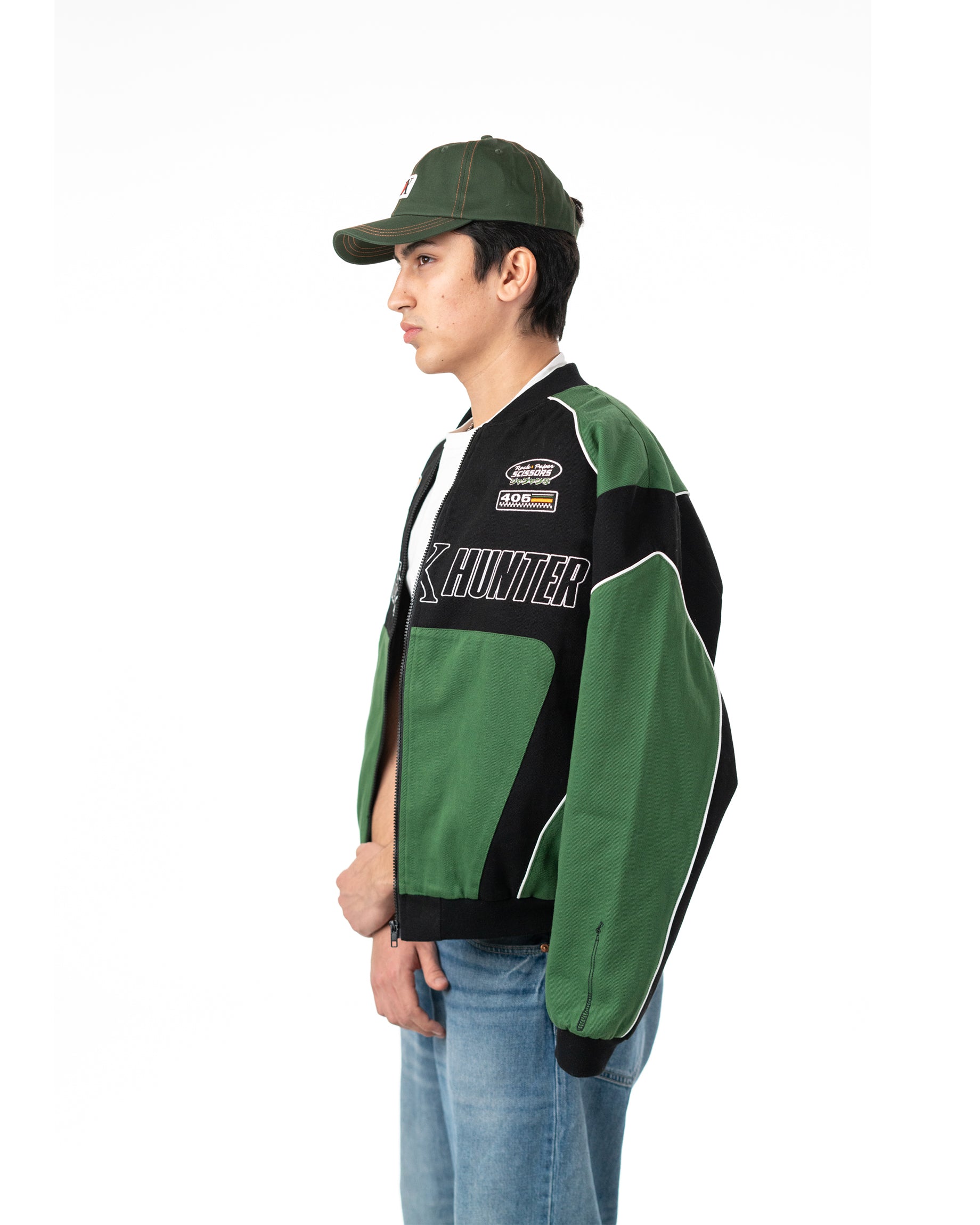 Three quarter back view of male model wearing the officially licensed green and black Gon racing jacket