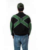 Full back view of male model wearing the green and black Gon racing jacket with matching green cap