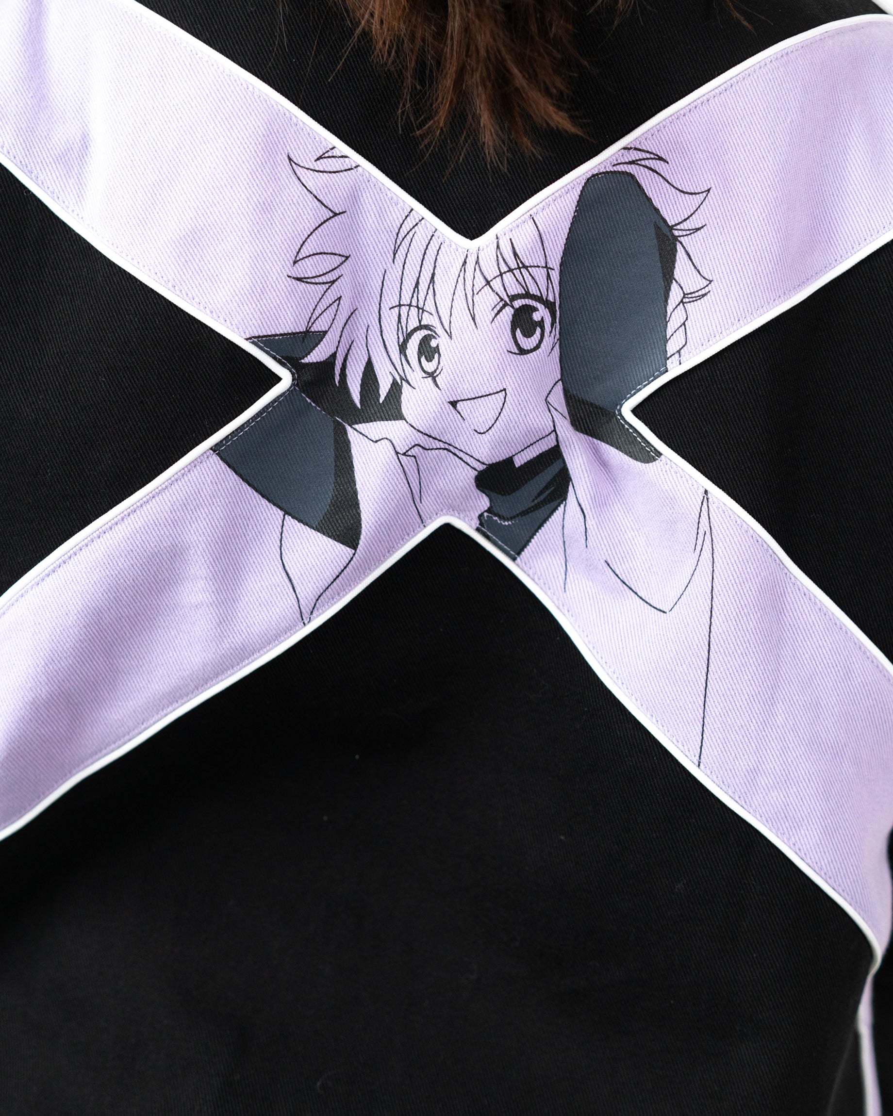 Close up of the lavender X graphic on the back of the Killua racing jacket with Killua Zoldyck print