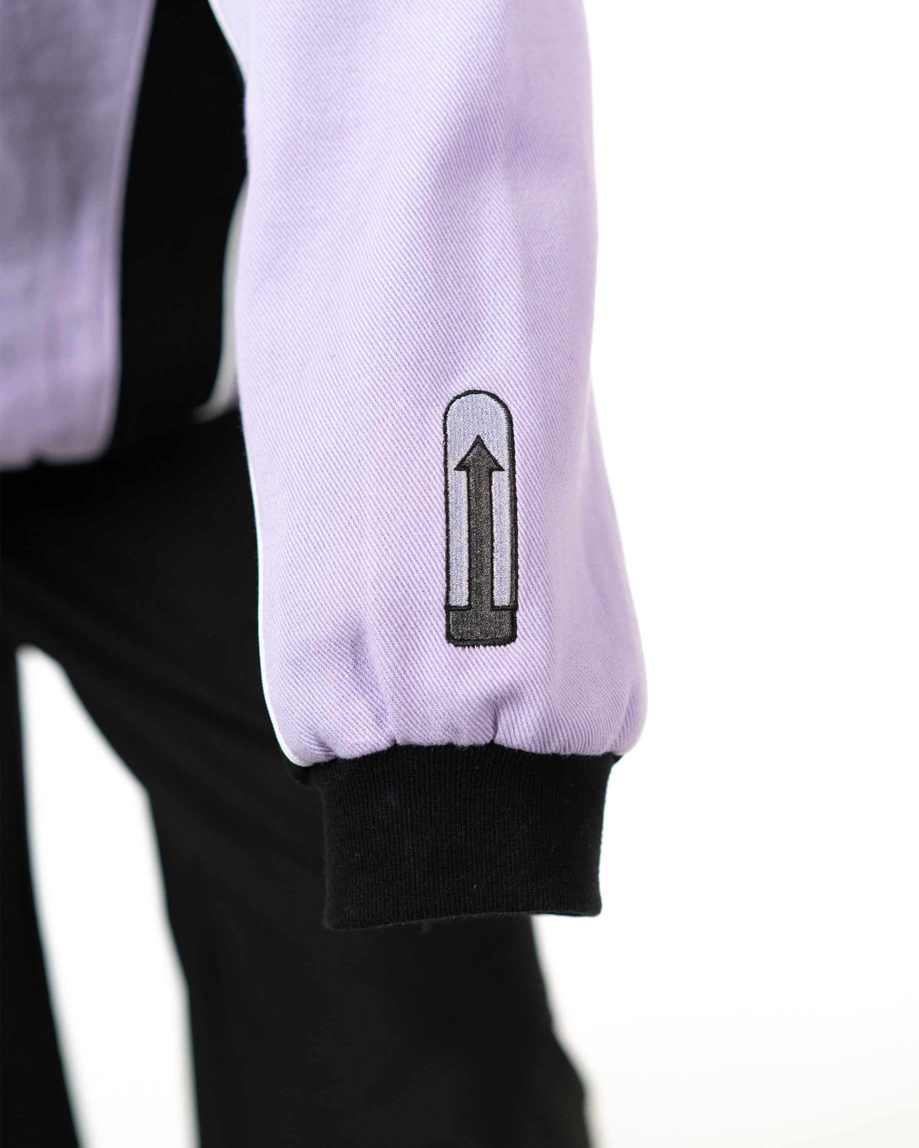 Detailed close up of the lavender sleeve cuff with a zipper closure and custom electricity needle graphic