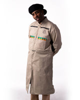 Front view of the beige side of the long reversible coat on a model.