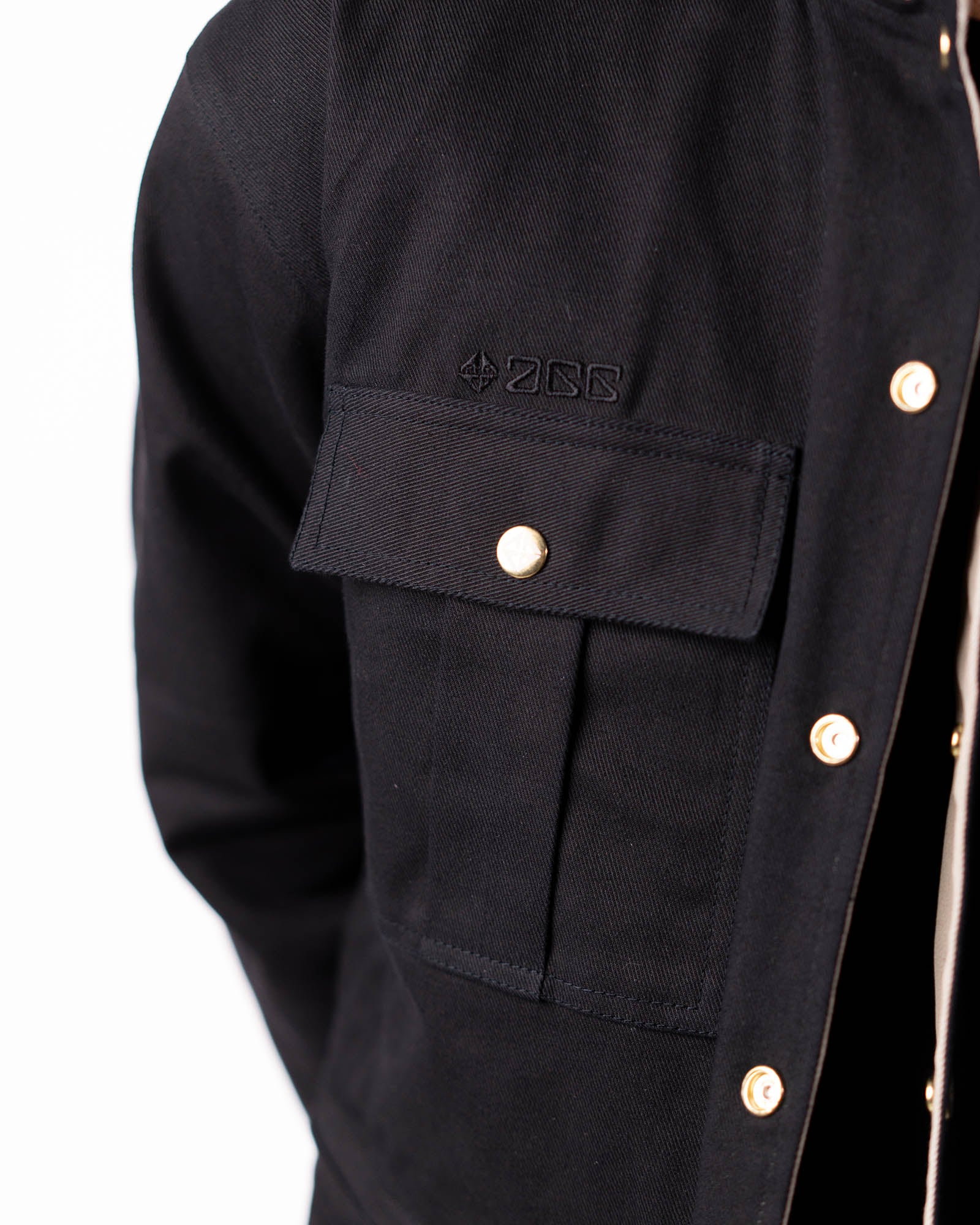 Detailed close-up of the chest pocket and cuff construction on the black side.