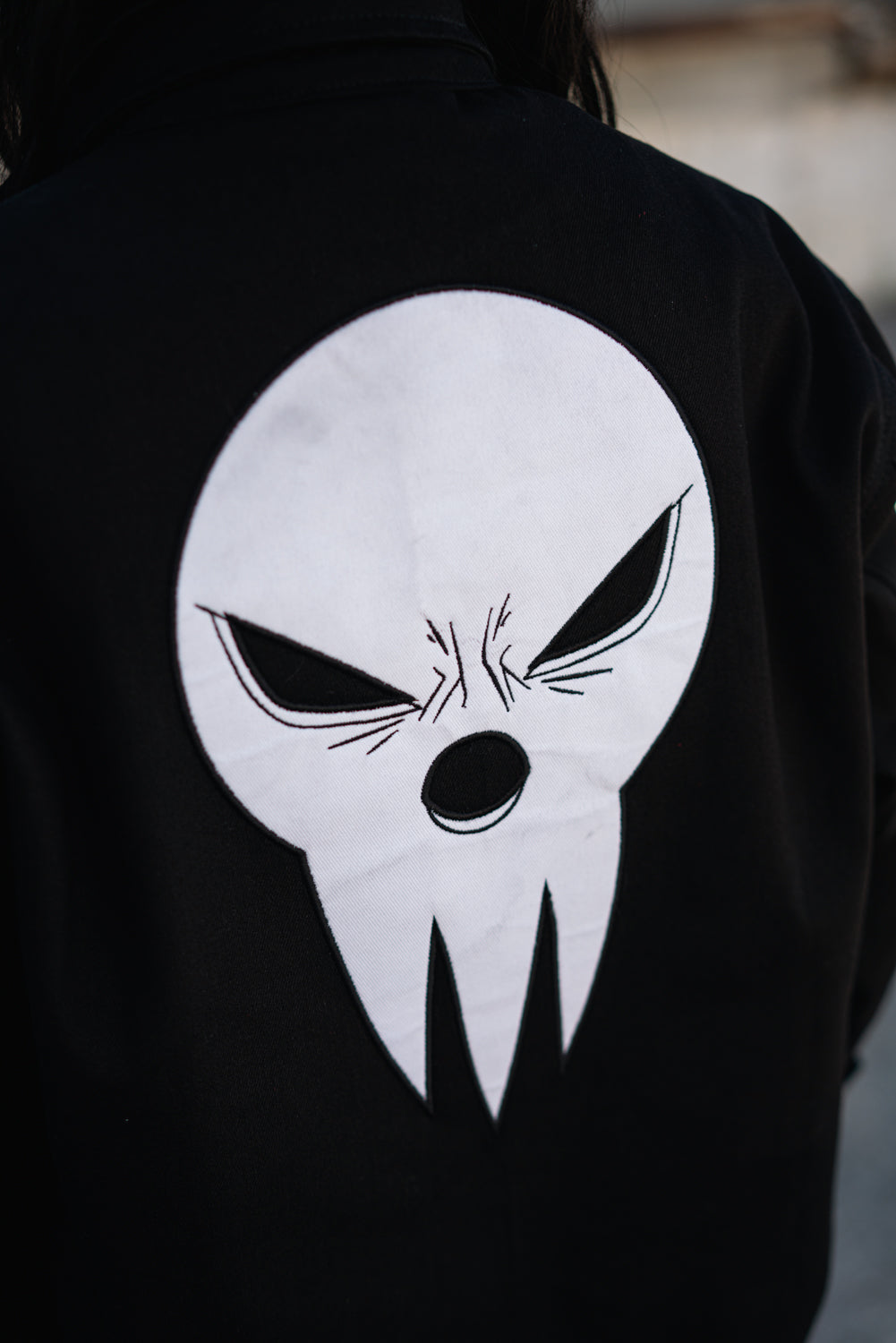 Detailed close-up of the white Shinigami mask embroidery on the back
