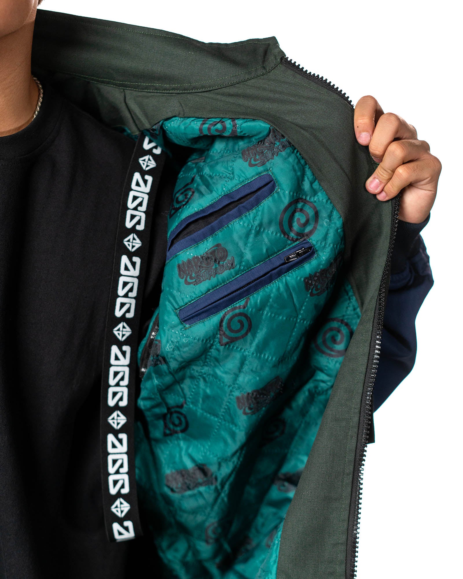 Naruto Shippuden Jonin Jacket interior view with teal quilted lining, zip pockets, Uzumaki symbols and Anime Gear Guru trim