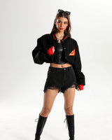 Female model wearing the short denim jacket in a lifestyle streetwear pose.