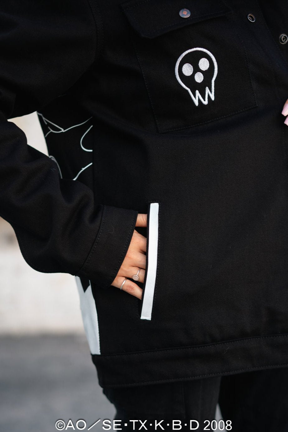 Detail view of the front hand pockets and white accent trim on the black denim.