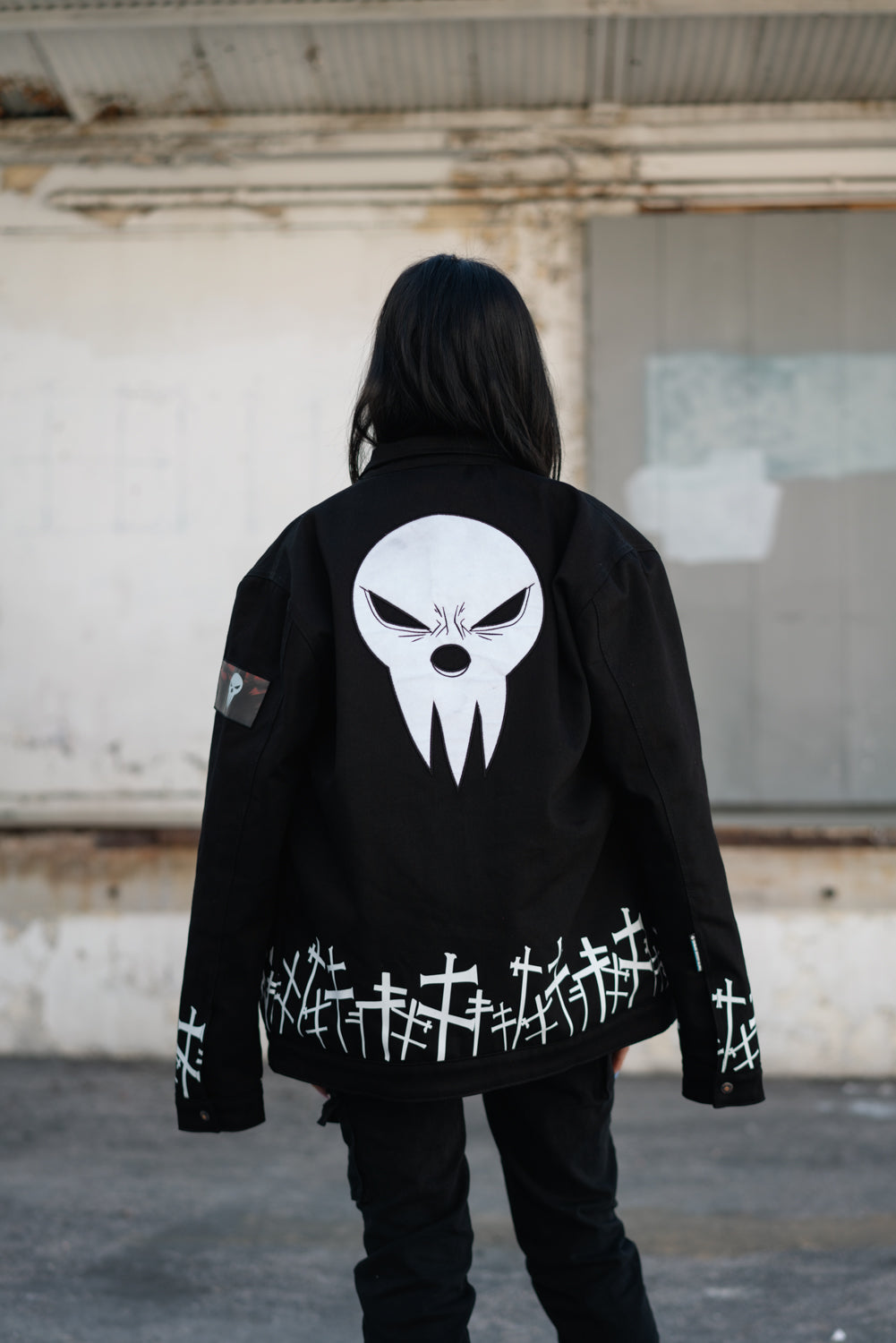 Distant back view of the jacket highlighting the reflective white embroidery