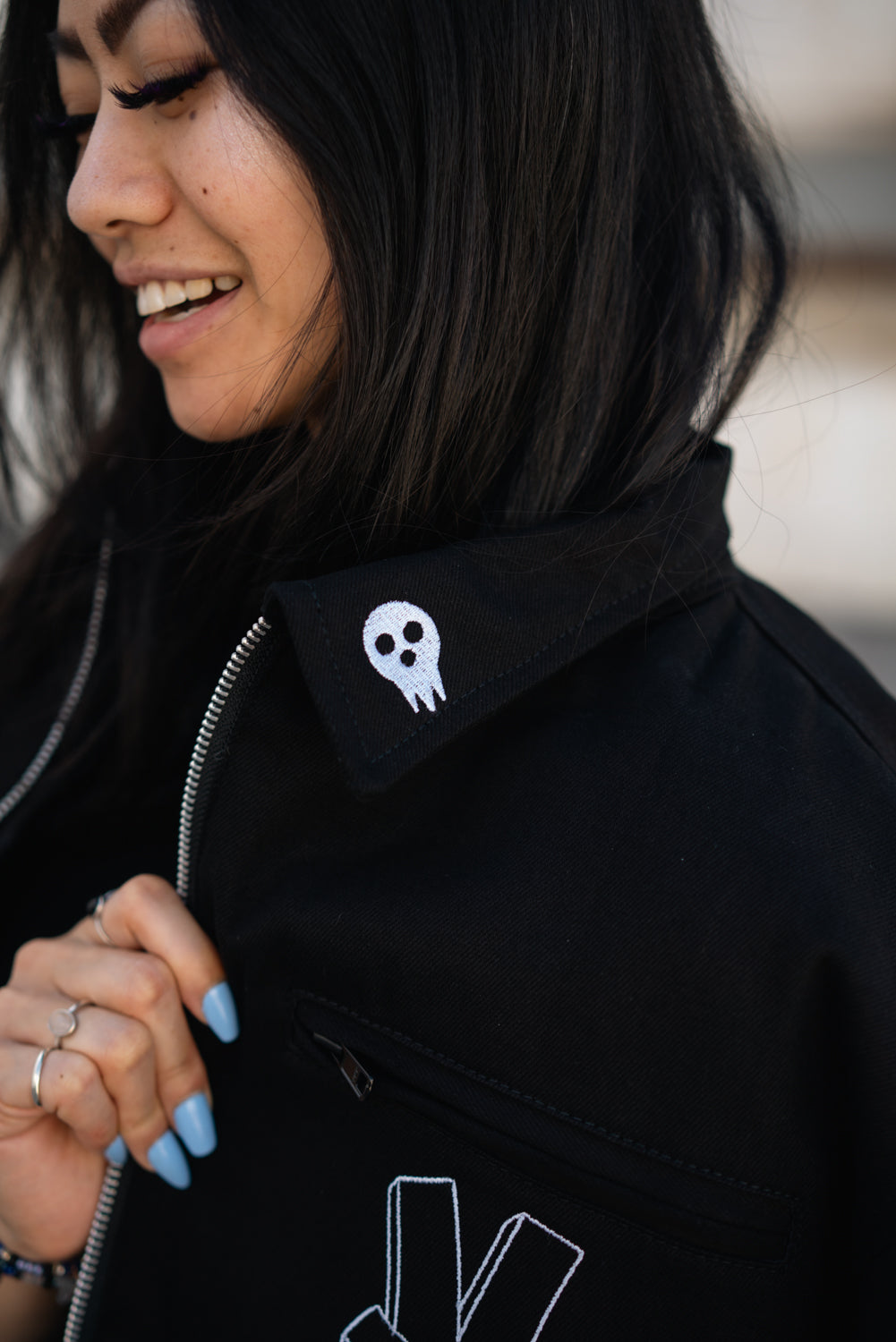Close-up of the jacket collar and zip-up front with model smiling