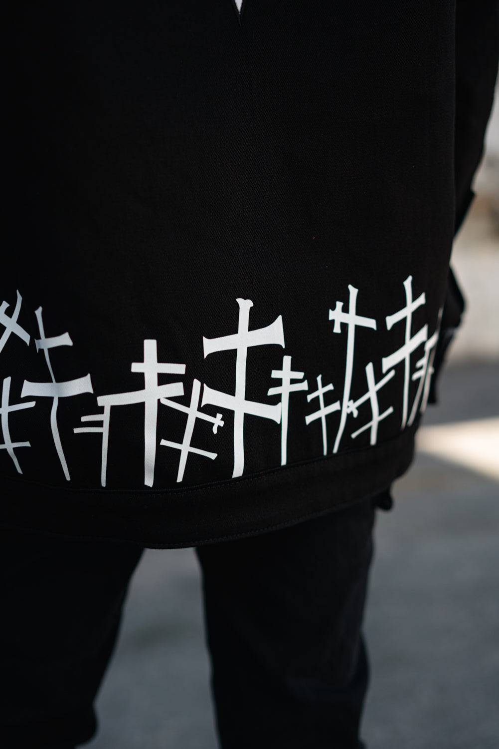 Close-up of the white graveyard cross pattern along the bottom hem