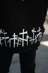Close-up of the white graveyard cross pattern along the bottom hem