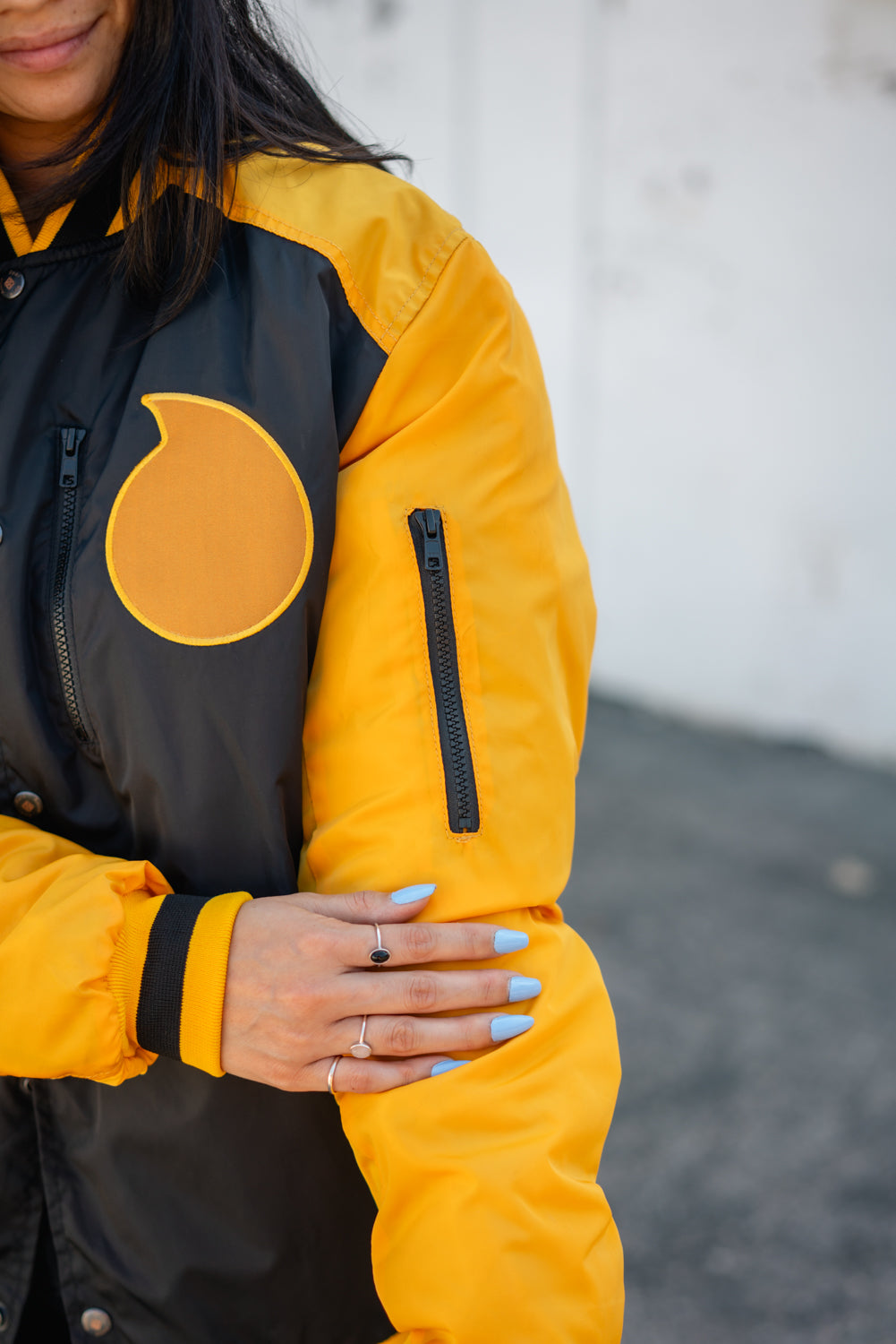 Detail shot of the yellow sleeve featuring a tactical zipper pocket and shoulder strap.