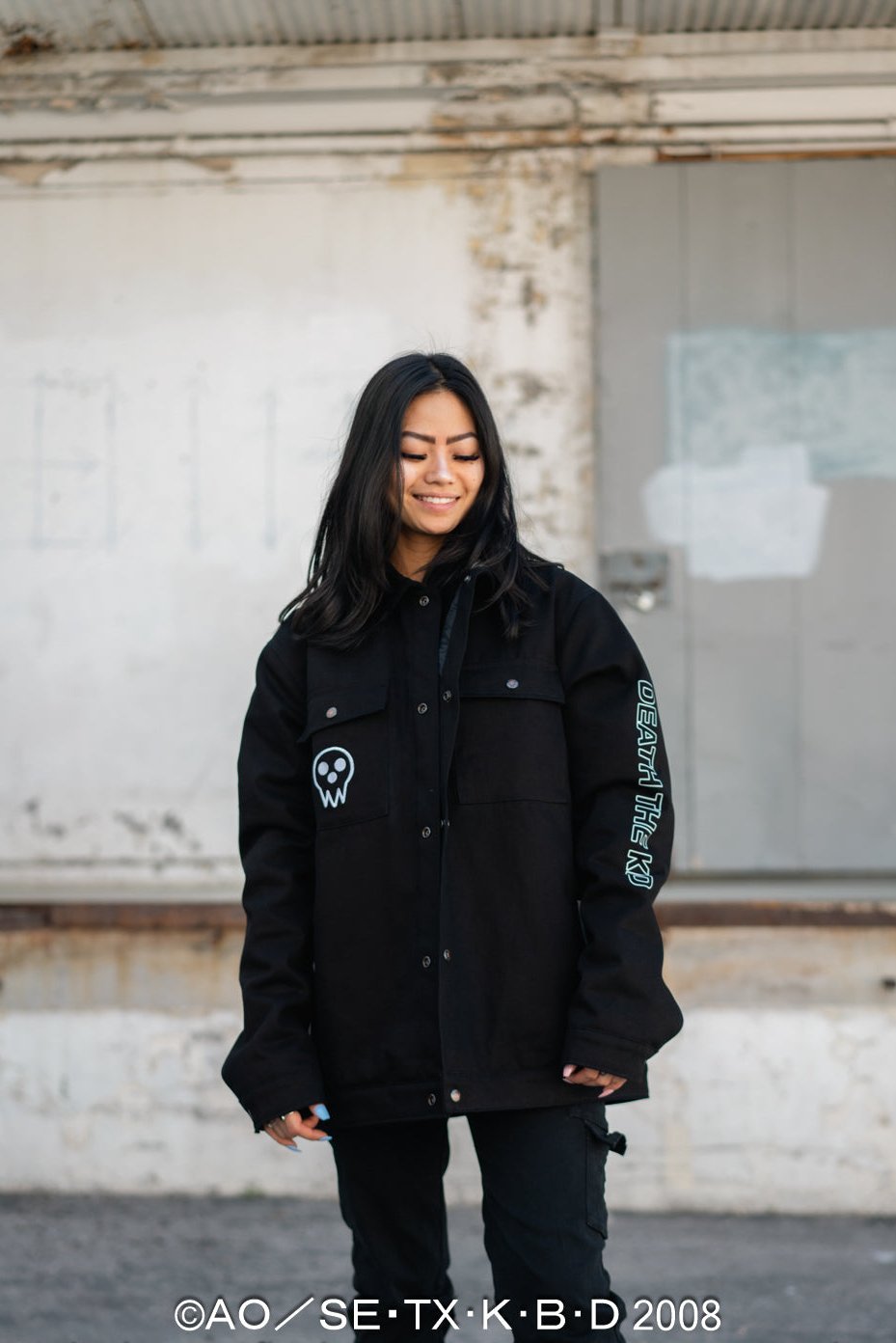 Full-body shot of the Death the Kid jacket styled with black cargo streetwear.