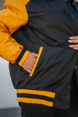 Close-up of the front hand pocket and the yellow-striped ribbed bottom hem.