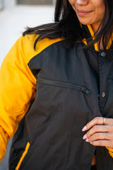 Close-up of the jacket collar and black snap-button front with yellow sleeves.